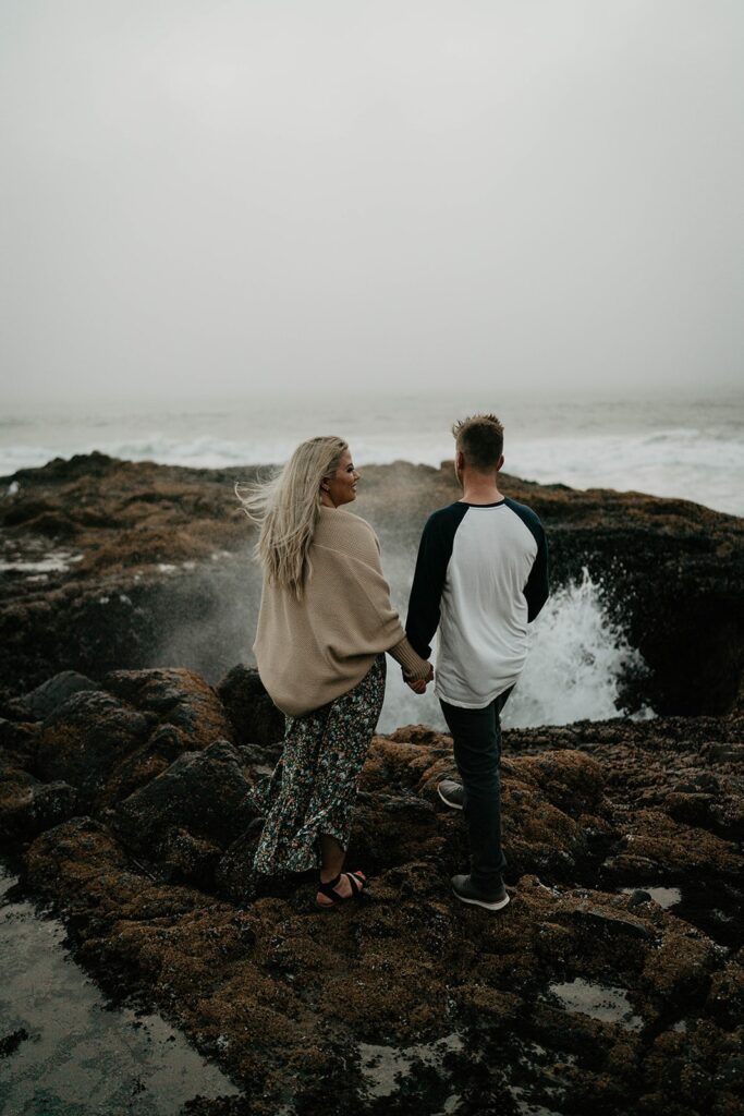 Couple standing in front of Thor's Well during their Cape Perpetua engagement session