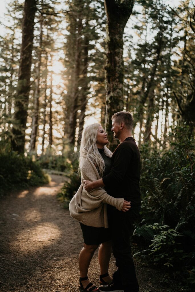 Couple hugging in the forest during their Oregon Coast engagement photos