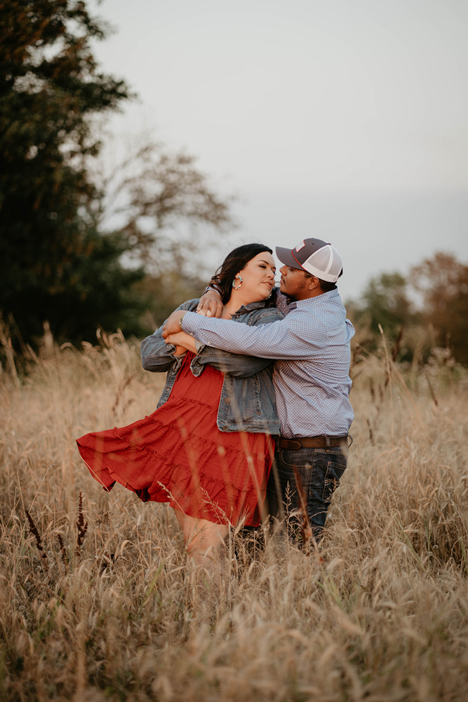 A woman being hugged from behind by her fiance in a field at Champoeg State Park.
