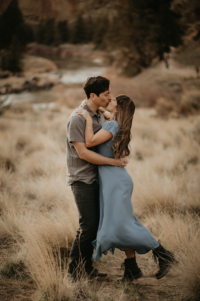 A couple kissing in a field at Smith Rock