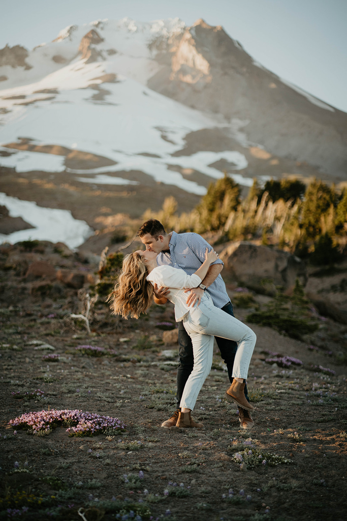 A couple kissing with Mt. Hood in the background at the Timberline Lodge.