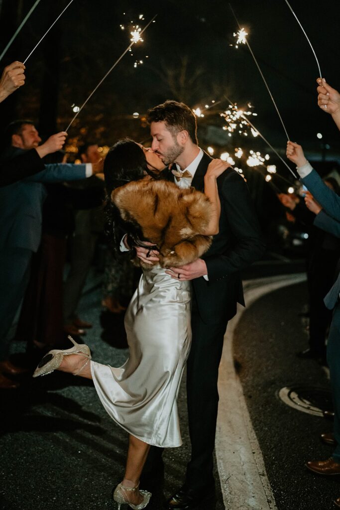 Bride and groom kiss while leaving their Blockhouse Portland wedding with a sparkler exit