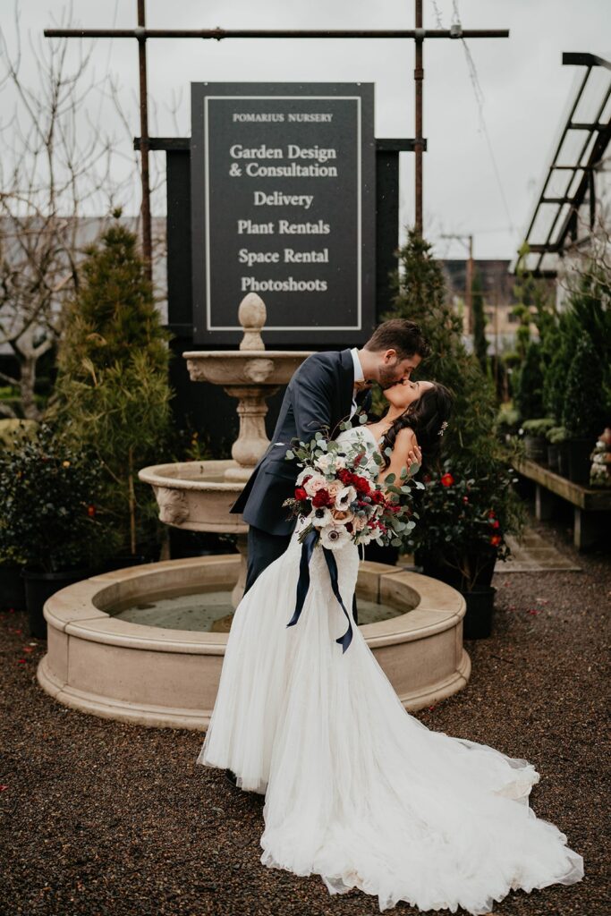 Bride and groom kiss in front of a fountain during their Blockhouse Portland wedding 