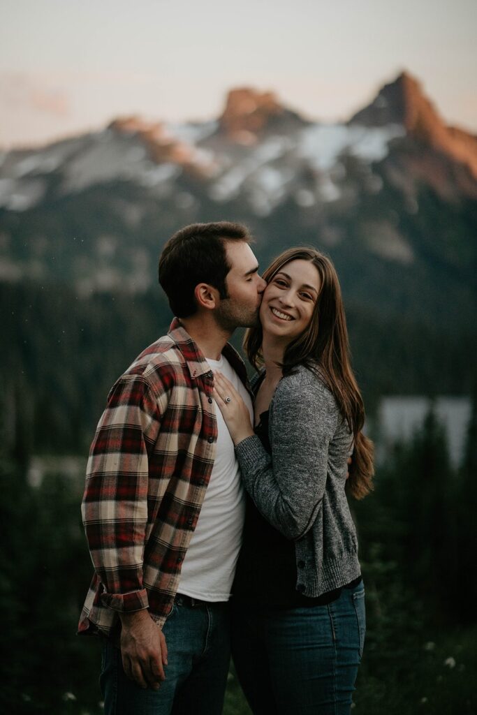 Man kissing woman on the cheek during Mt Rainier engagement photos