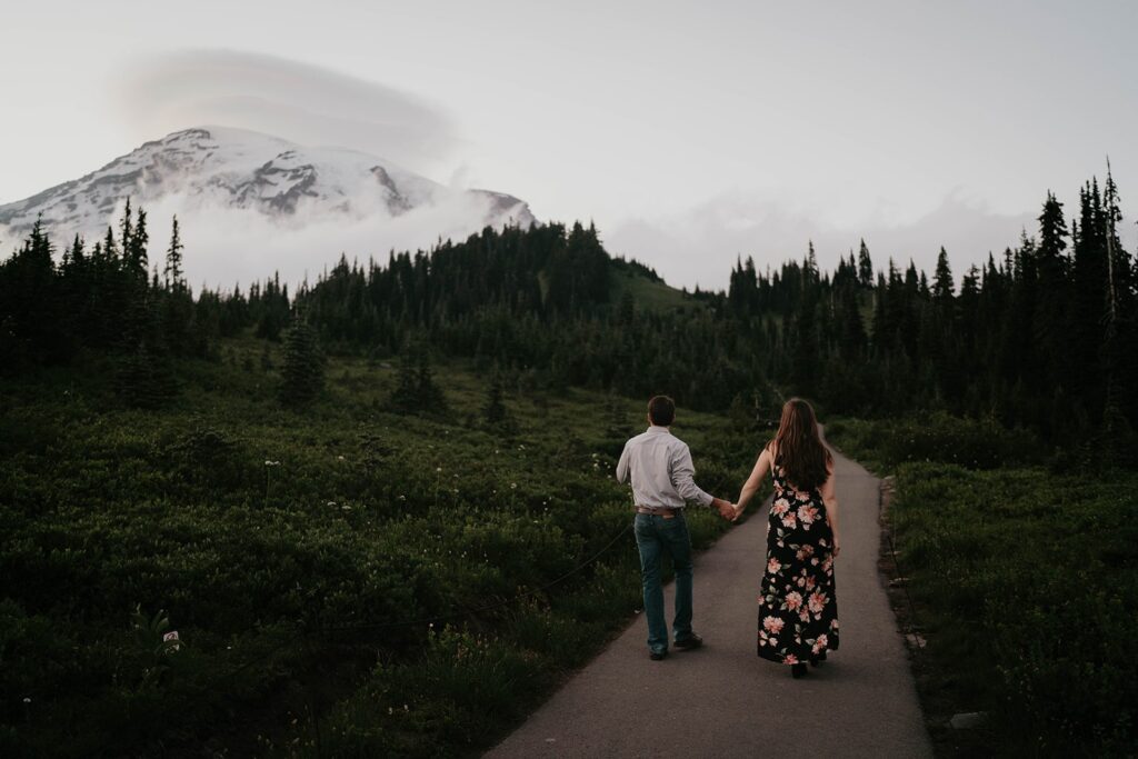 Couple holding hands, walking down the trail in Paradise during Mt Rainier engagement photos