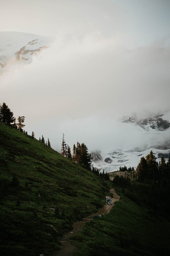 Couple walking up a trail at Mt Rainier for their hiking engagement photos