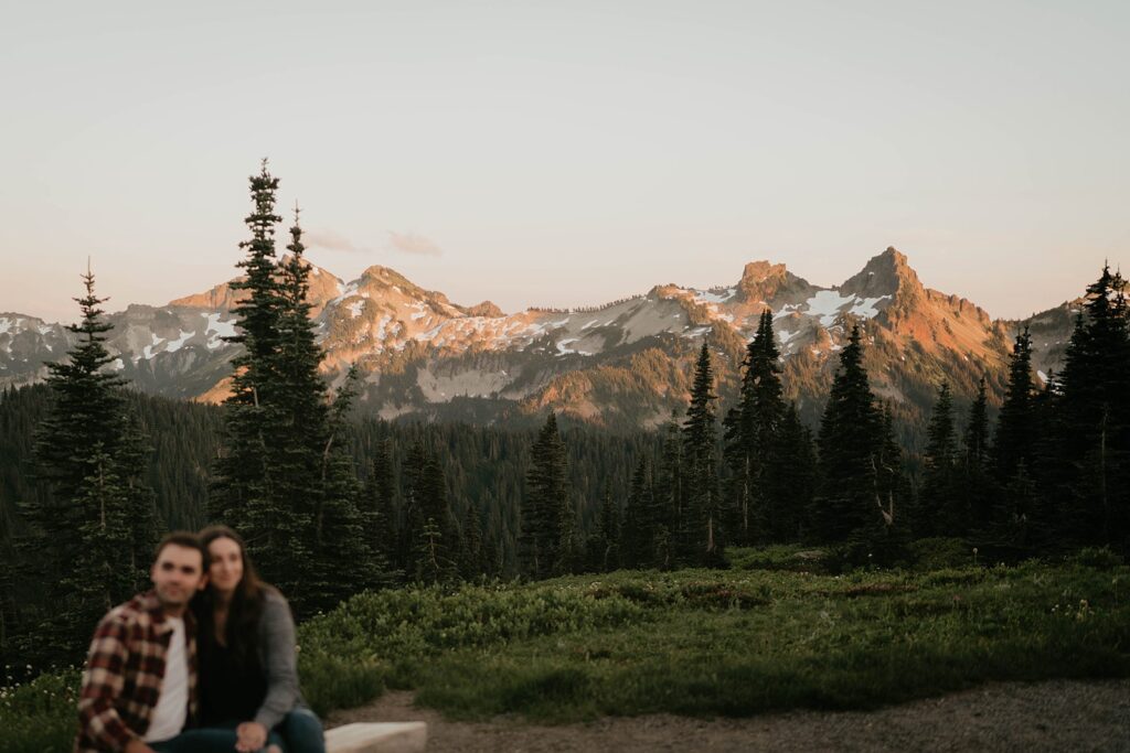 Couple sitting on a bench at sunset during Mt Rainier engagement photos
