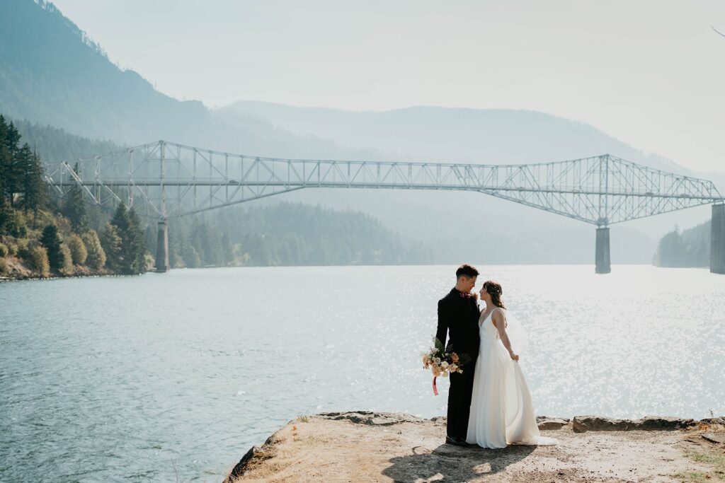 Bride and groom standing in front of Cascade Locks for their Thunder Island wedding