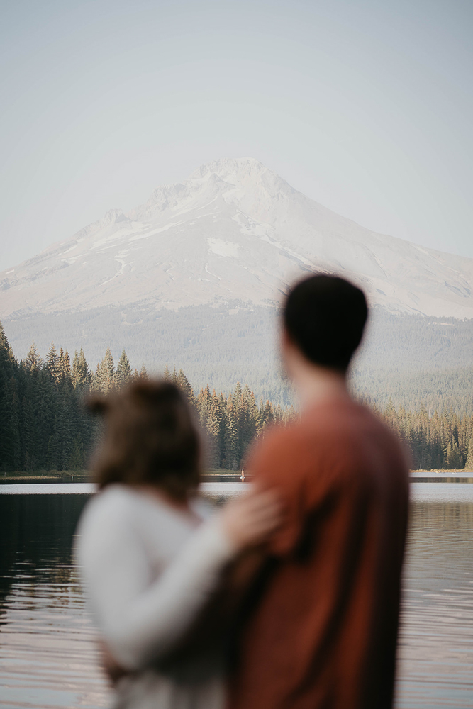 A couple at Trillium Lake staring at Mt. Hood in the background. 