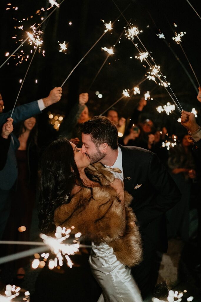 Bride and groom kiss while leaving their Blockhouse Portland wedding with a sparkler exit