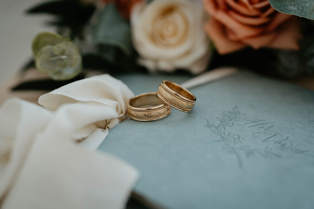two rings on wedding vows, with roses in the background. 