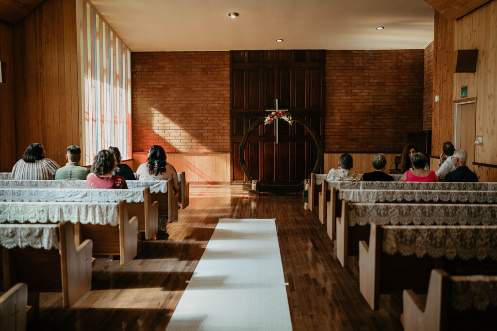The inside of Hubbard Chapel, with guests sitting in the pews. 
