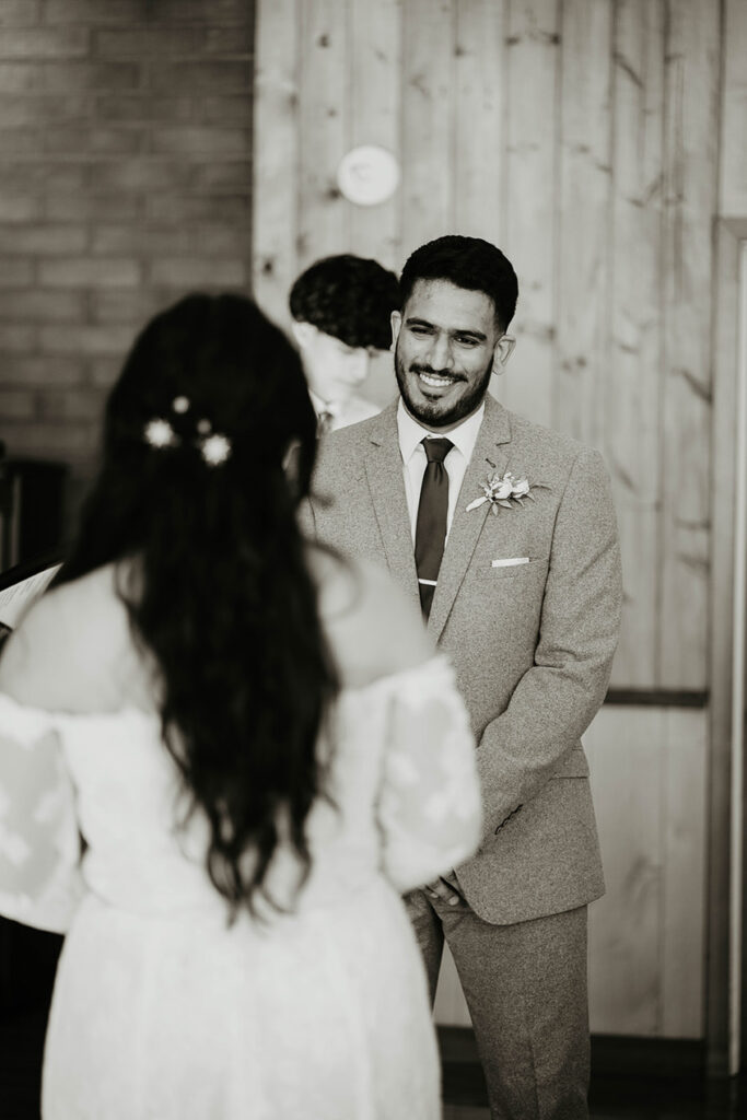 The groom smiling affectionately at his bride. 