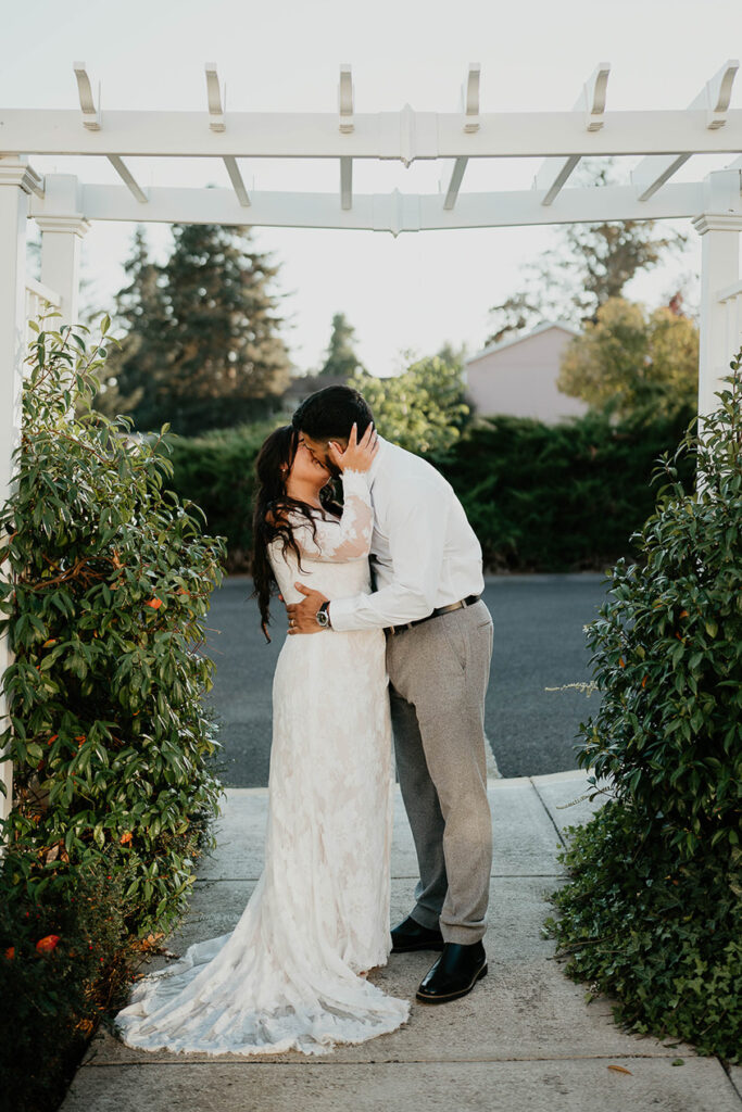 The bride and groom kissing under a gazebo. 