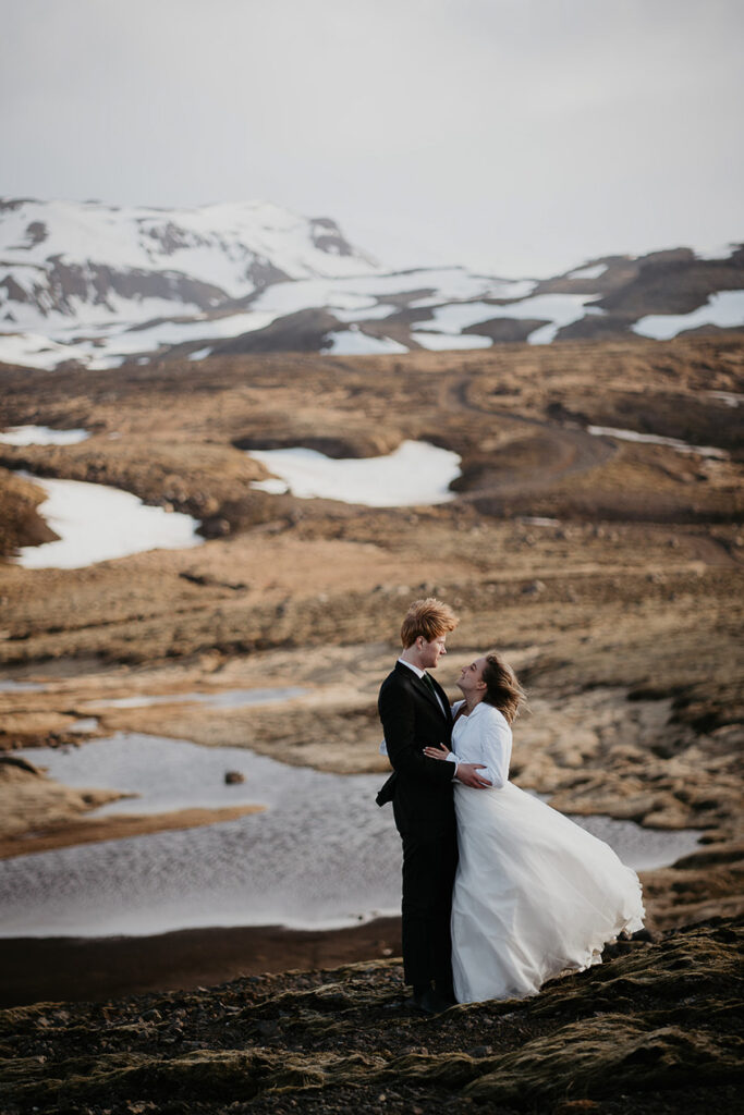 A bride and groom looking lovingly into each other's eyes with Icelandic snow fields in the background. 