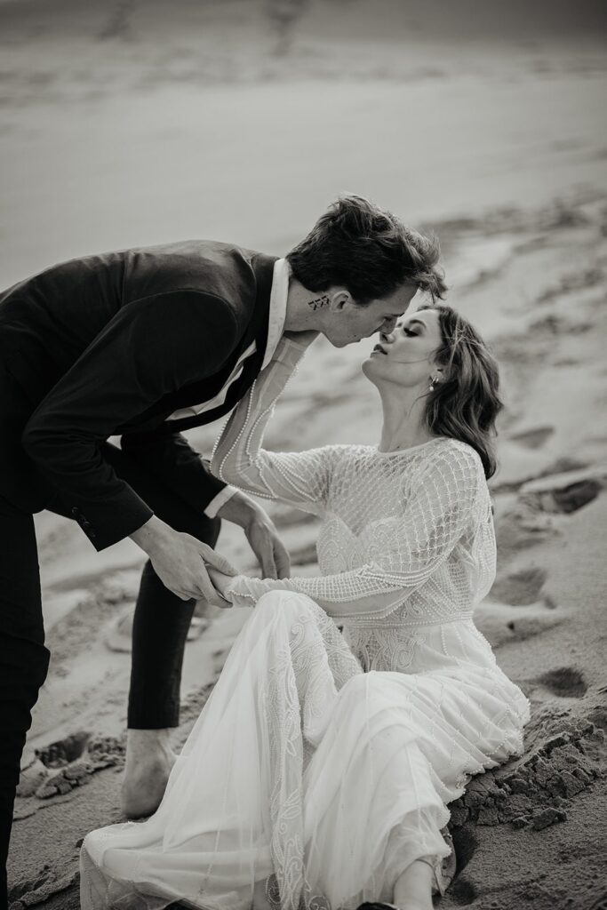 Bride and groom kiss on the sand dunes in Oregon during their adventure elopement