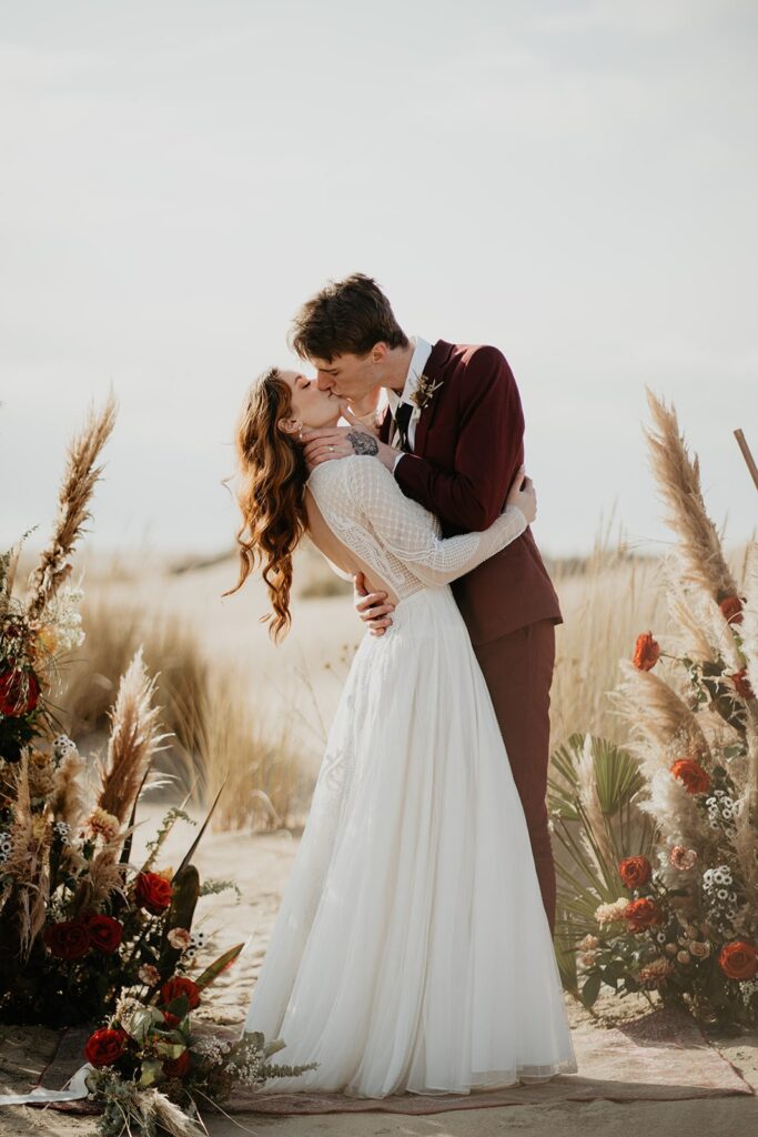 Bride and groom kiss during their Oregon sand dunes elopement ceremony