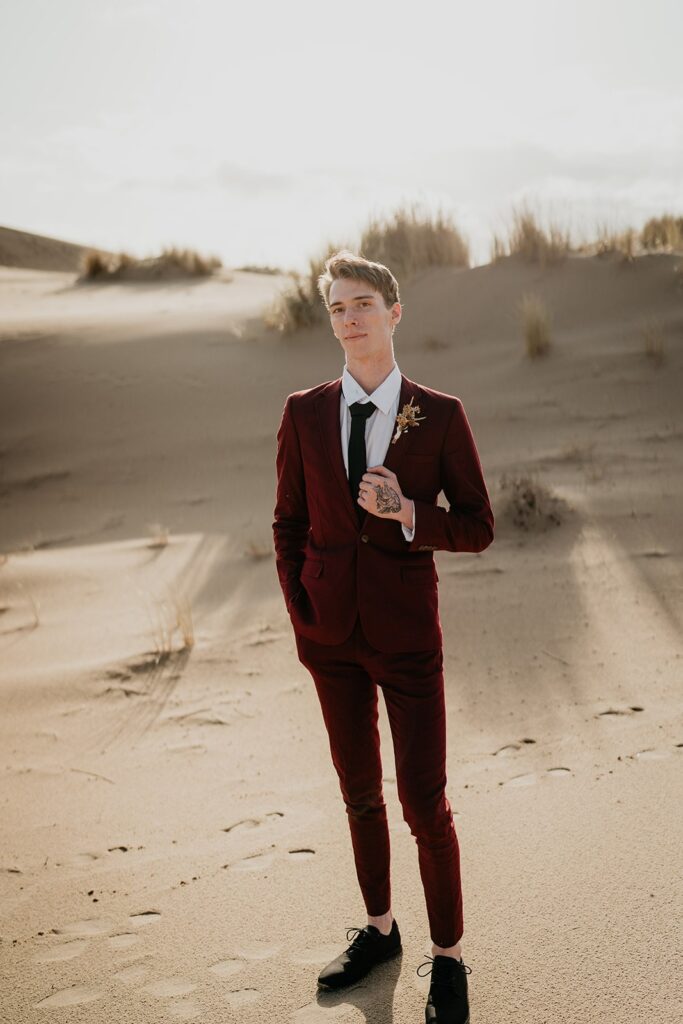Groom wearing beige suit during Oregon elopement on the sand dunes