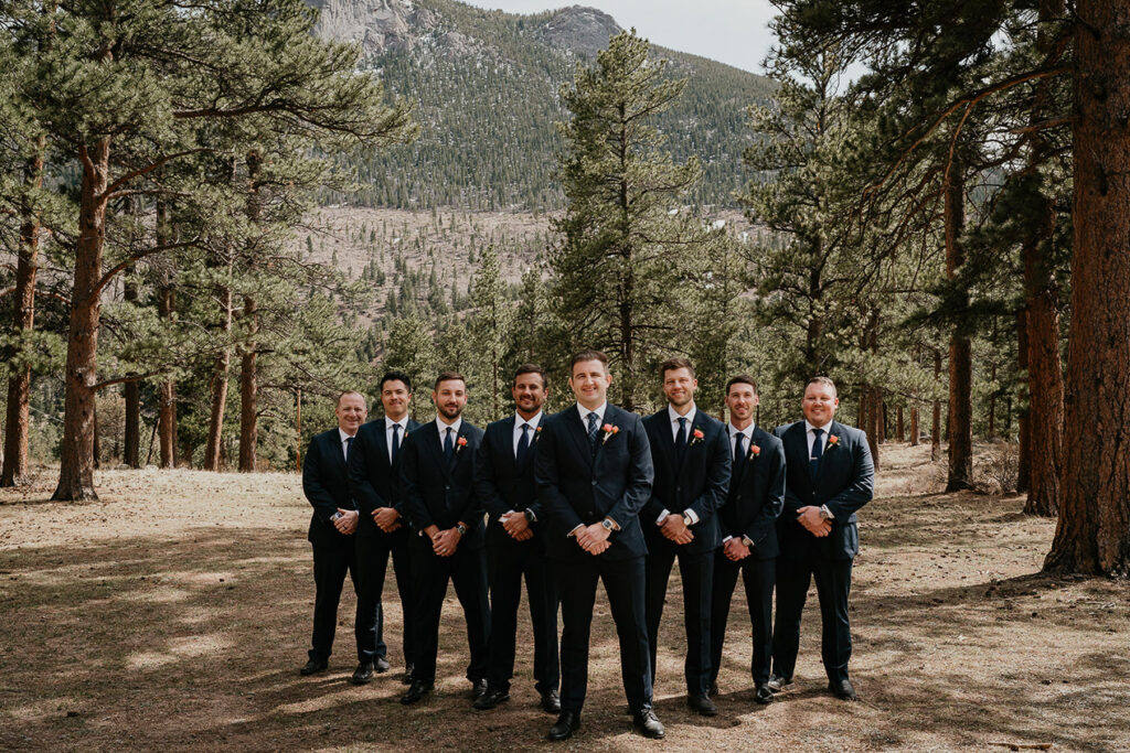 The grooms with his groomsmen standing in the forest. 