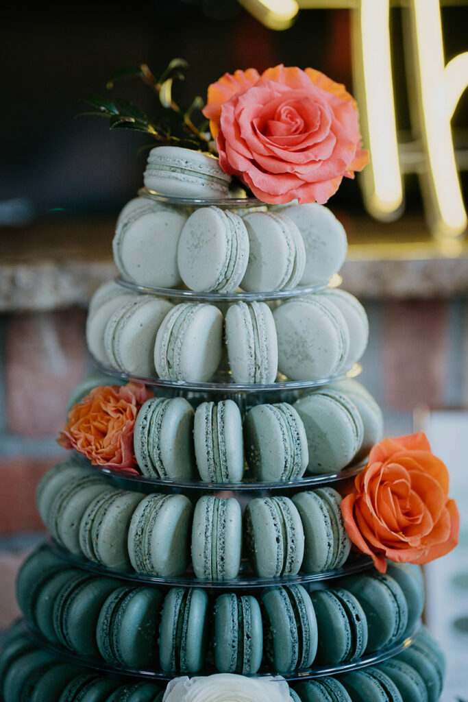 pink and red roses and turquoise macaroons stacked in a tower. 