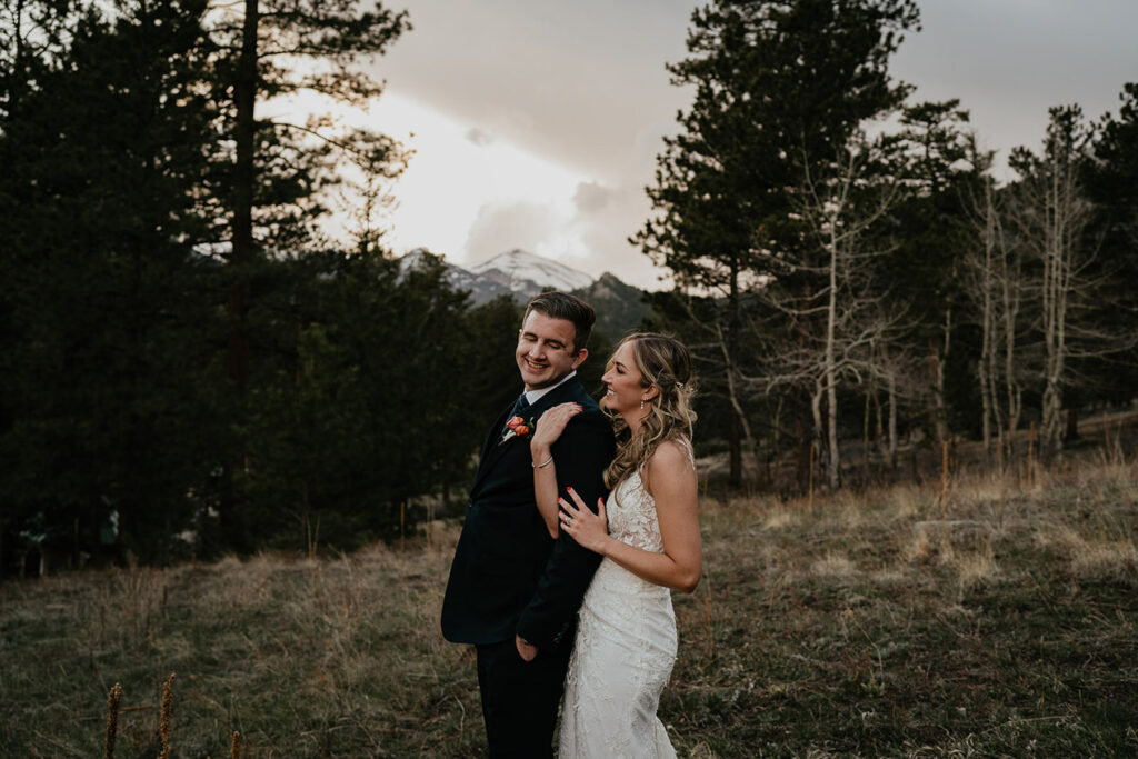 The bride and groom holding each other in the forest at Estes Park. 