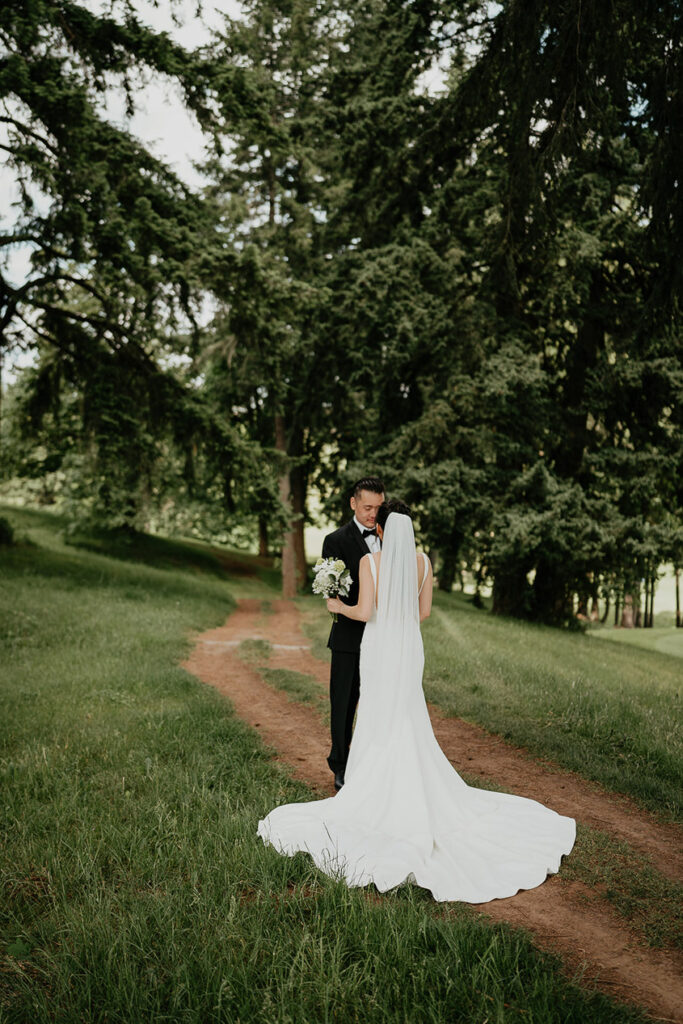 Judith and Joshua holding each other under a tree at Oregon Golf Club before their wedding. 