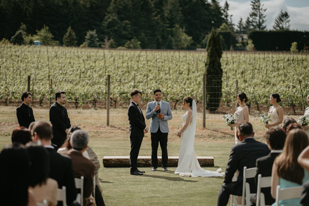 Judith and Joshua's wedding ceremony at Oregon Golf Club, with vineyards in the background. 