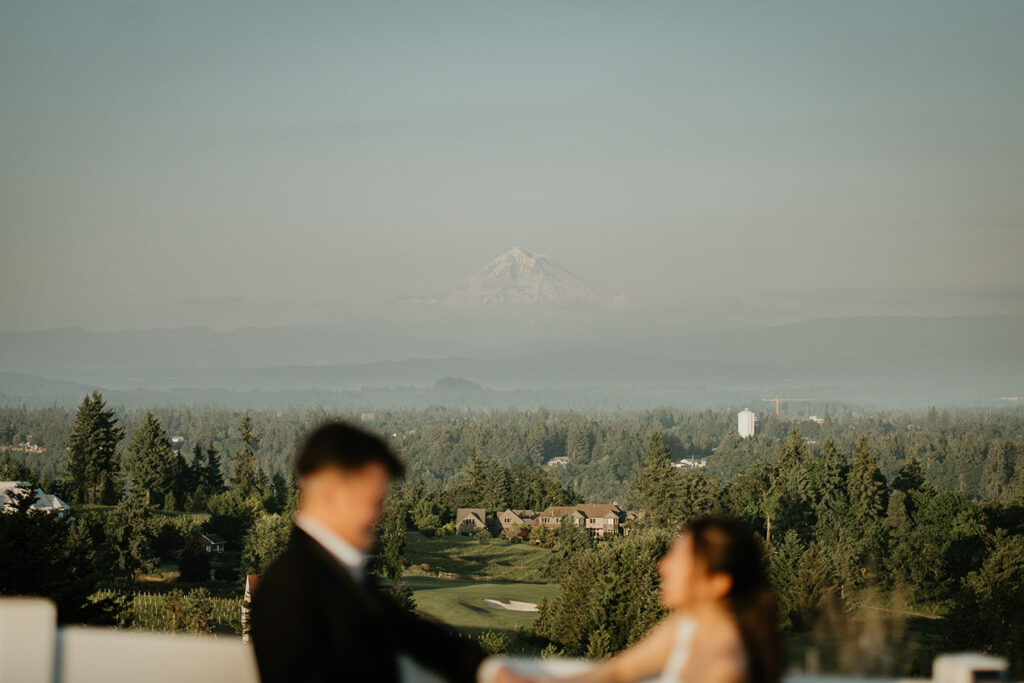 Joshua and Judith holding hands with the Oregon Golf Club and Mt. Hood in the distance. 
