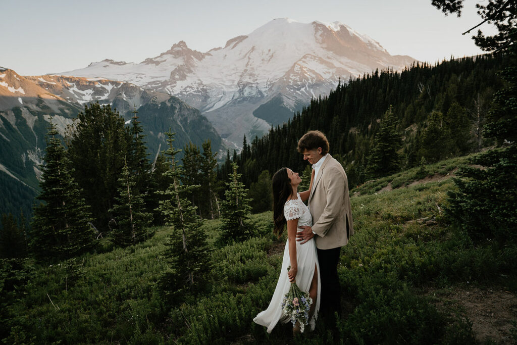 The husband holding her wife with Mt Rainier in the background. 