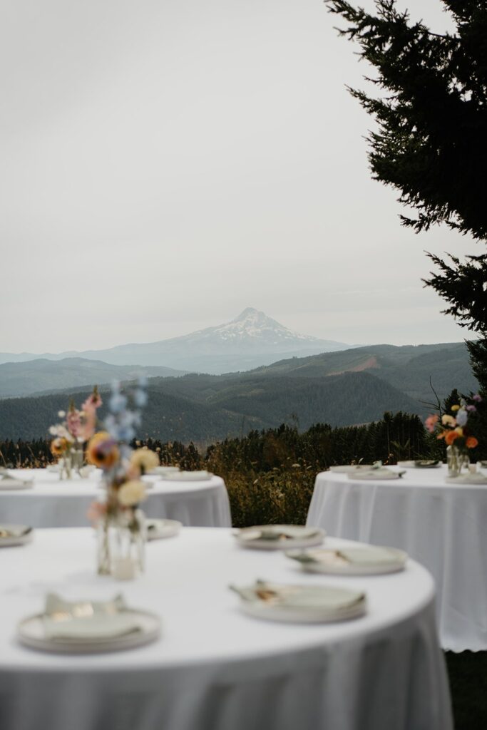 White reception tables with summer flowers overlooking Mt Hood at Gorge Crest Vineyards wedding