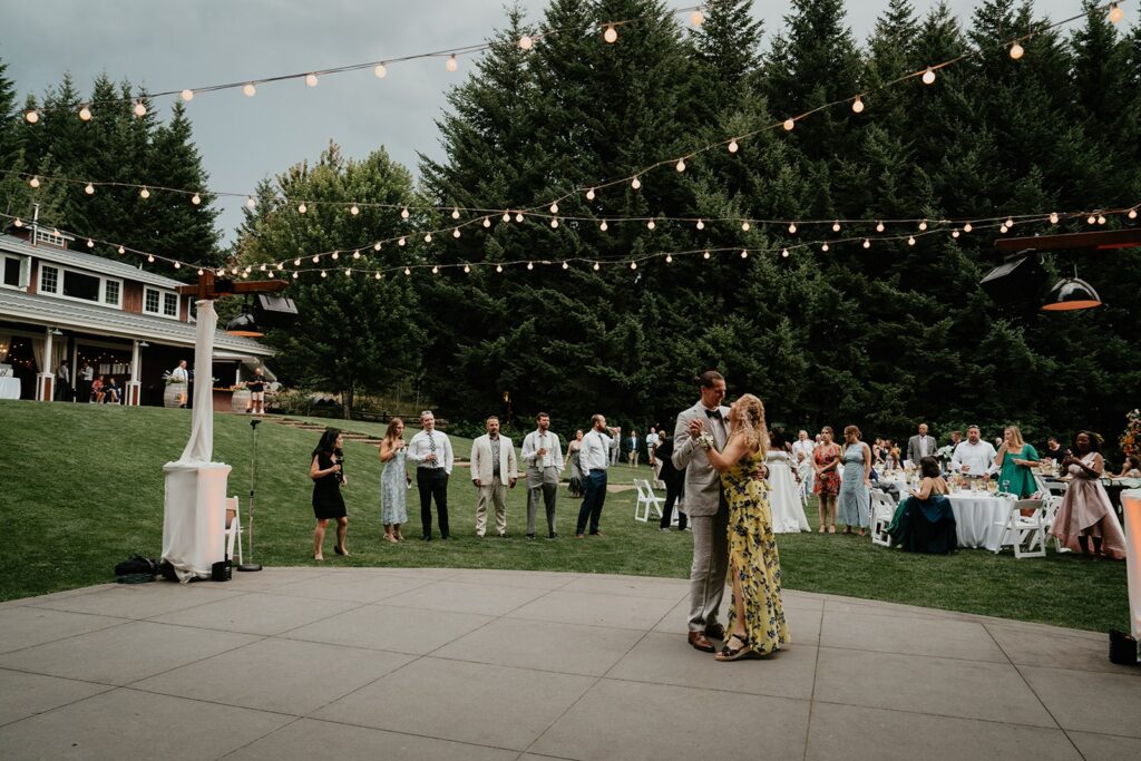 Mother son first dance under string lights at outdoor wedding reception