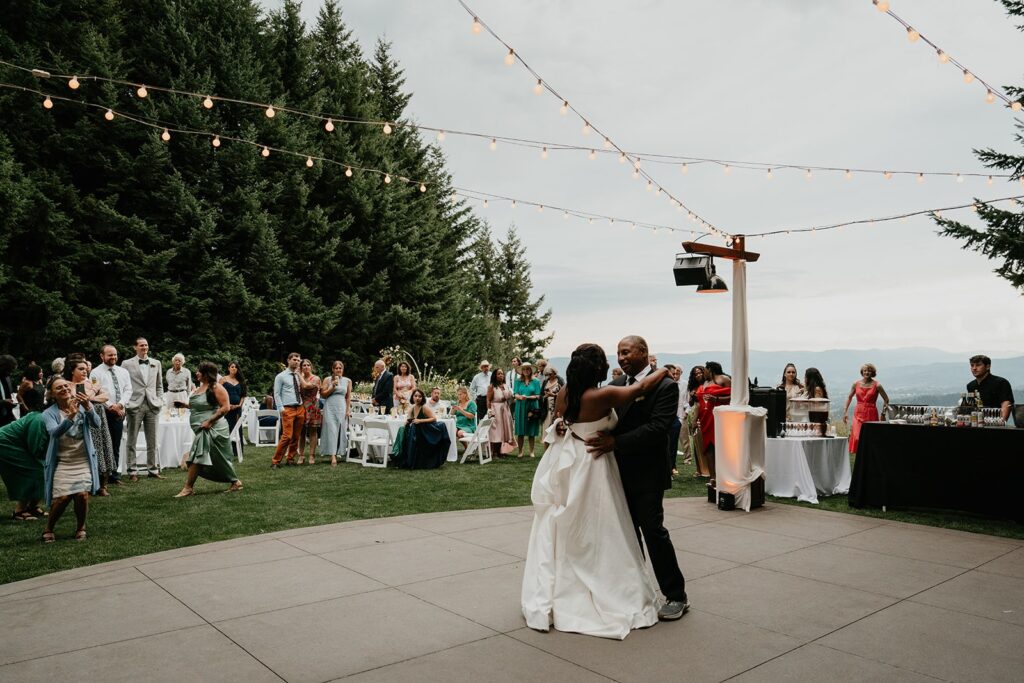 Father daughter first dance under string lights at outdoor wedding reception