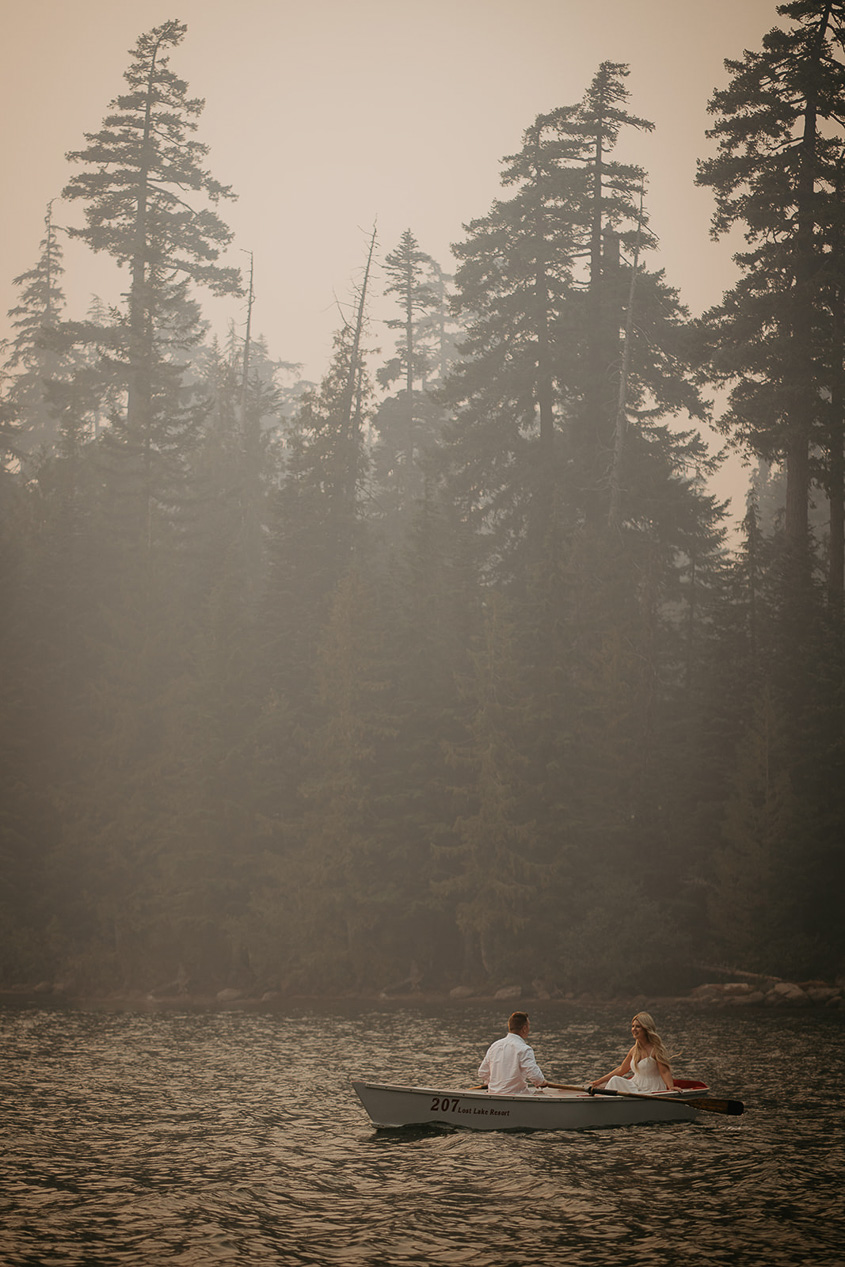 The couple rowing a boat on a smokey Lost Lake.