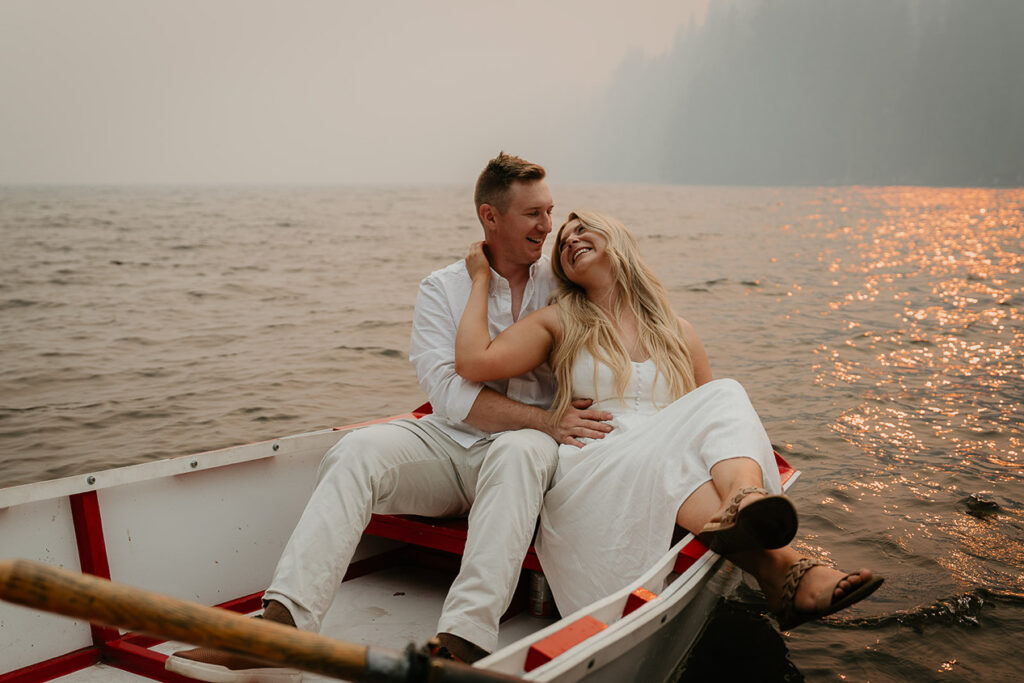 The couple holding each other on a row boat in Lost Lake while smoke fills the air. 