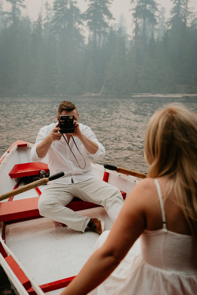 the groom-to-be taking a polaroid of his future wife while in a row boat on Lost Lake. 