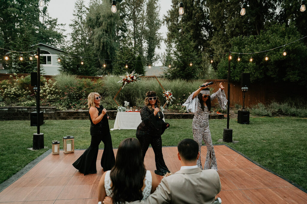 The moms of the newlyweds dancing in fun costumes. 