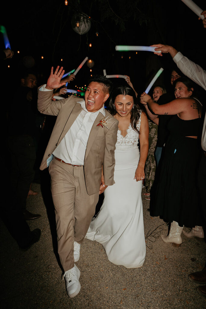 The couple making a grand exit as guests wave glow sticks. 