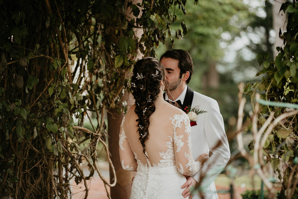 The bride and groom kissing, surrounded by ivy at Lairmont Manor. 
