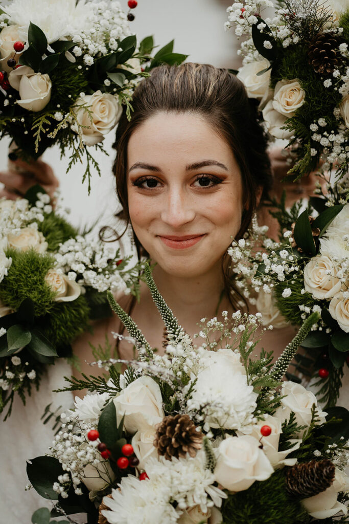 The bride surrounded by white roses and other greenery. 