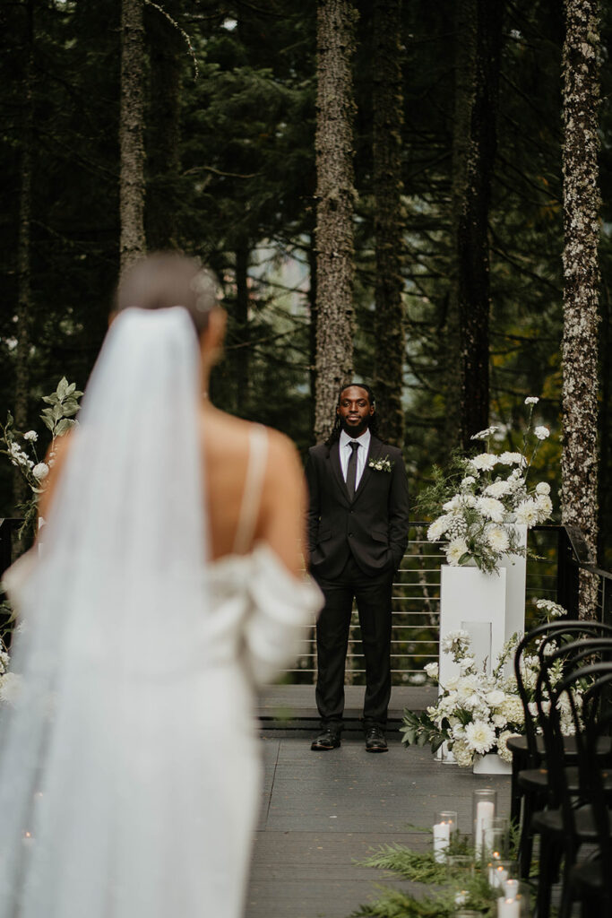 the groom waiting at the altar while his bride walks toward him. 