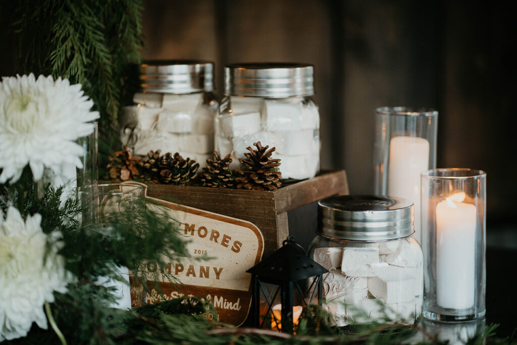 Jars of marshmallows, a box of pine cones, and candles. 