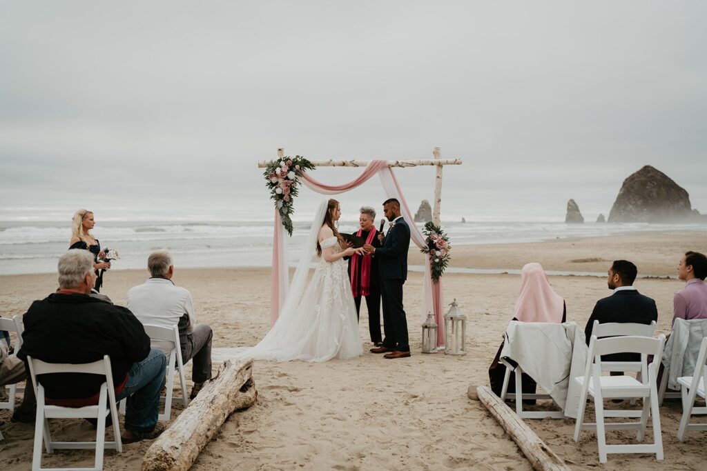 Bride and groom exchange vows on the beach during their elopement in Oregon