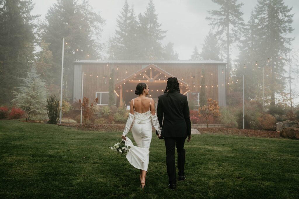 Bride and groom hold hands while walking on the grounds at Rocky Hill Events wedding venue in Oregon