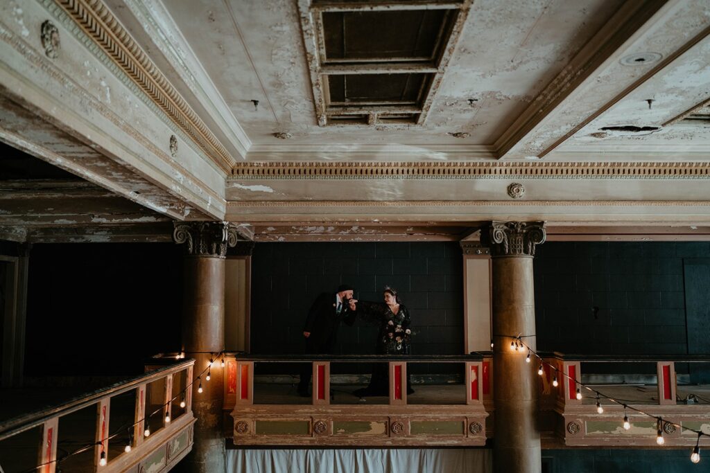 Bride and groom walk around the mezzanine at the Ruins at the Astor wedding venue