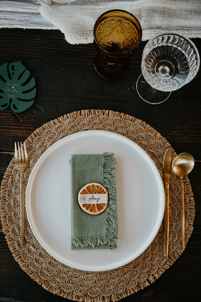 a close up of the place mat, cutlery, plate, and cups for the wedding reception. 