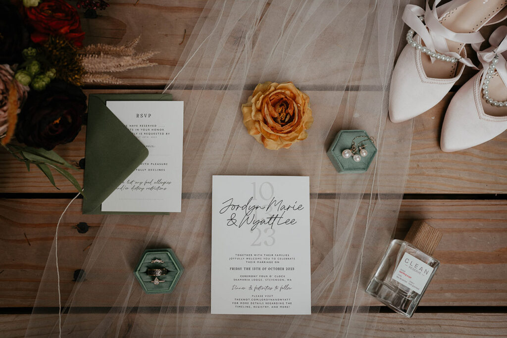 Wedding details, including the program, rings, perfume, earrings, vail, and heels. 