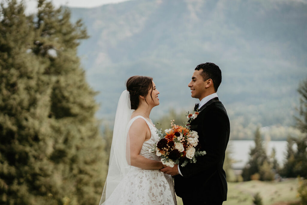 the bride and groom smiling with the Columbia River and mountains in the background. 