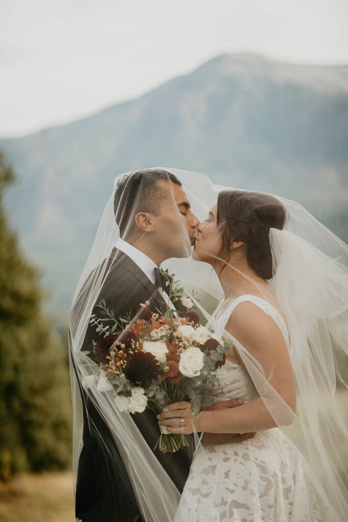 the bride and groom kissing under the vail at Skamania Lodge. 