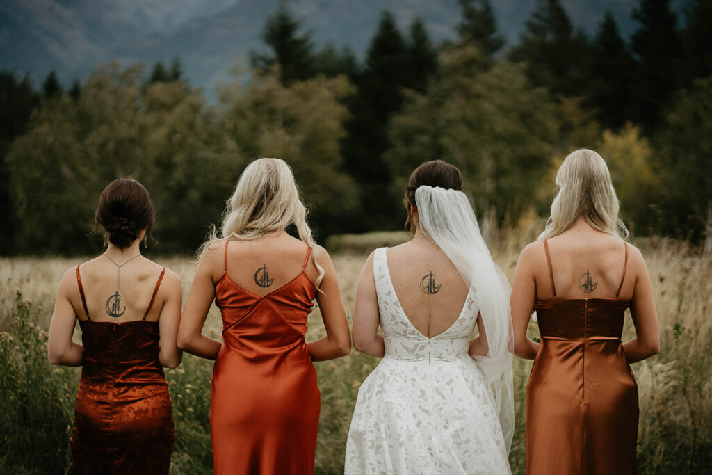 the bride and four of her bridesmaids showing off their identical tattoos. 