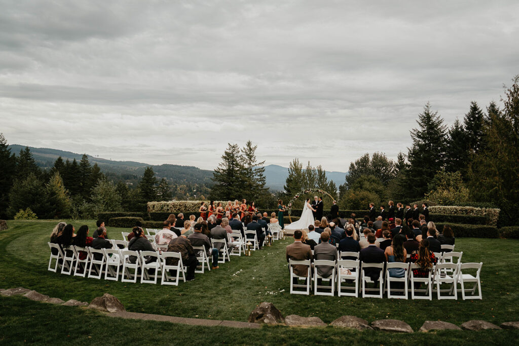 the wedding ceremony at Skamania Lodge with pine trees and mountains in the background. 
